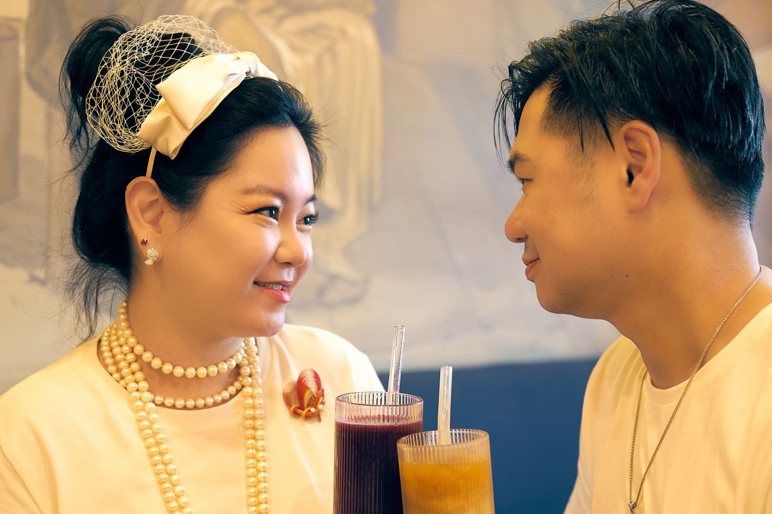 Jean-Marc and Nancy at a café table, raising their drinks to each other
