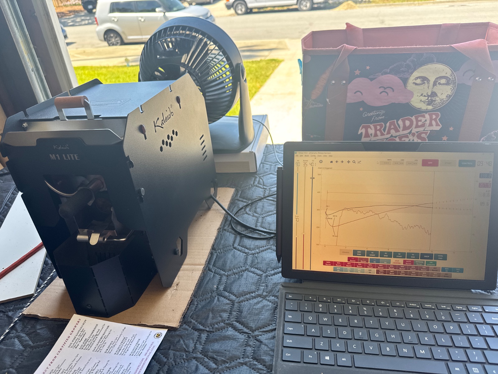A Kaleido roaster on the work bench next to a Surface tablet running the Artisan roast-profile software, mid-curve.